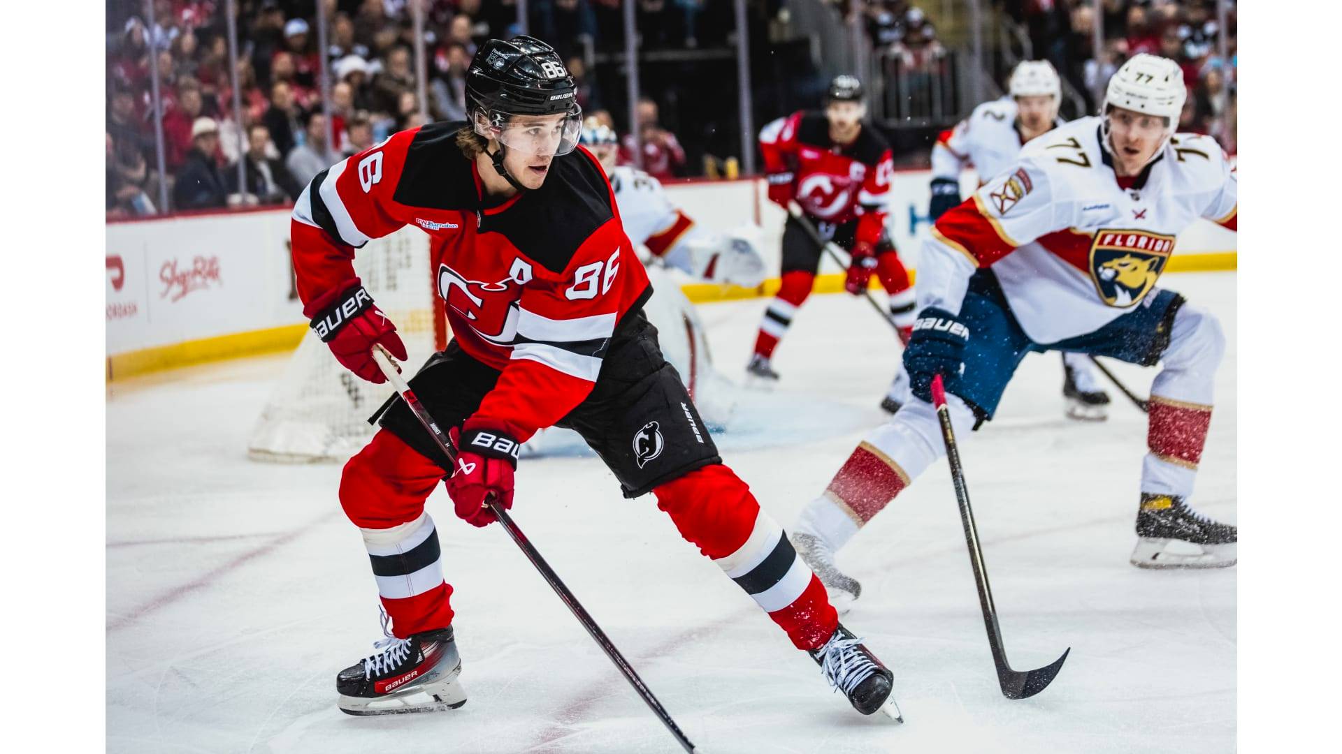 Jack Hughes handles the puck for the Devils in a game against the Panthers.