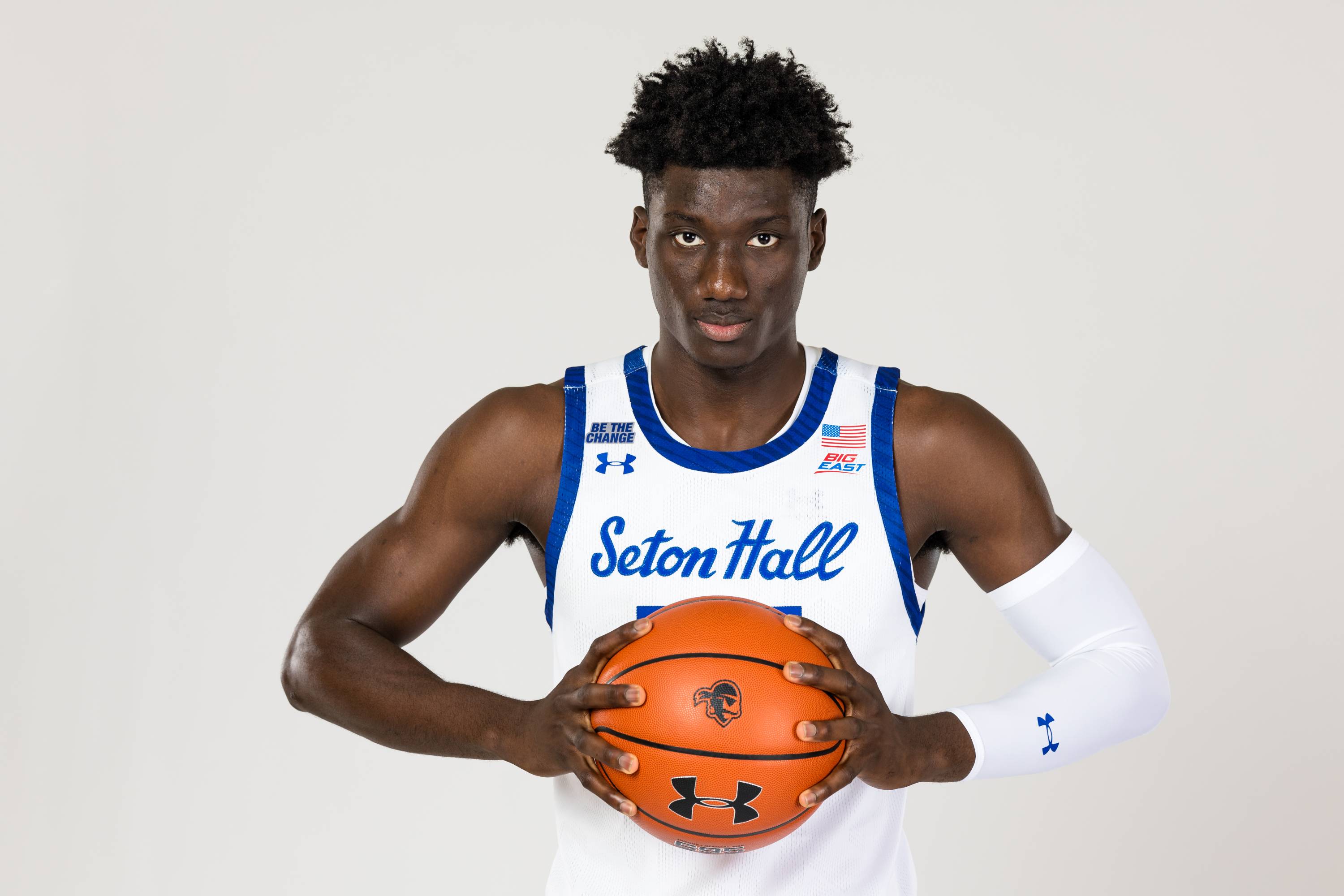 Godswill Erheriene posing with a Seton Hall basketball.