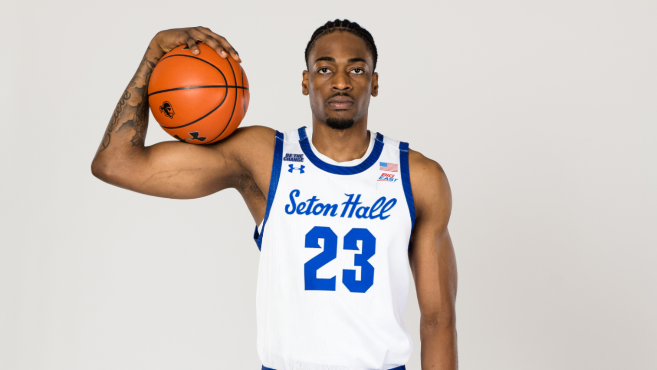 Emmanuel Okorafor (23) posing with a Seton Hall basketball.
