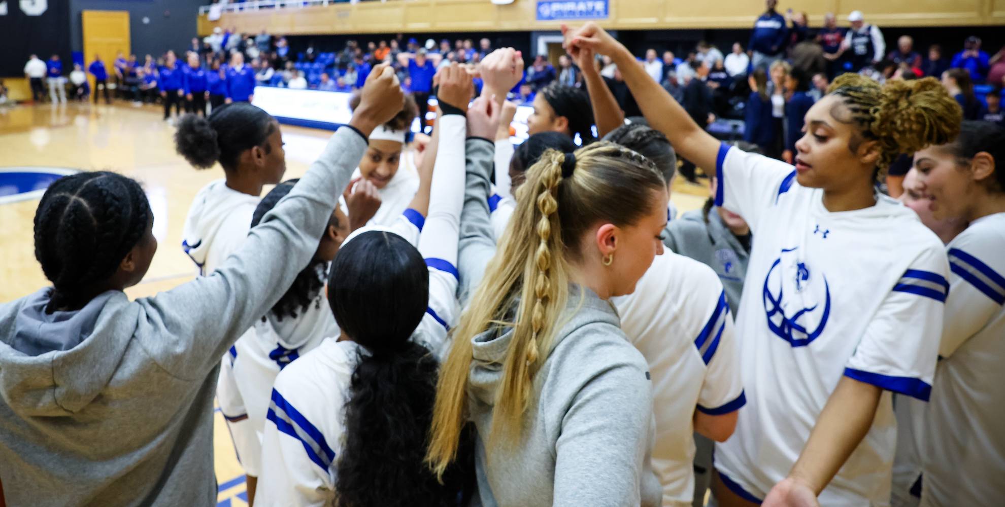 Women's basketball in a huddle altogether